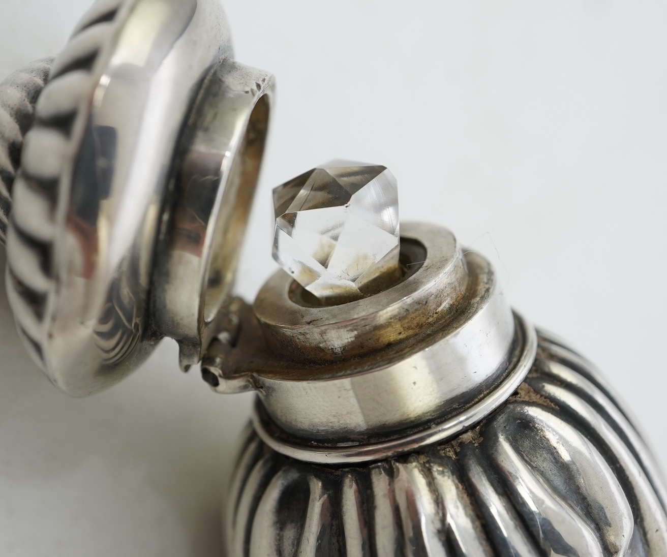 A late Victorian silver scent flask, of spiral tear drop form, with hinged cover and glass stopper